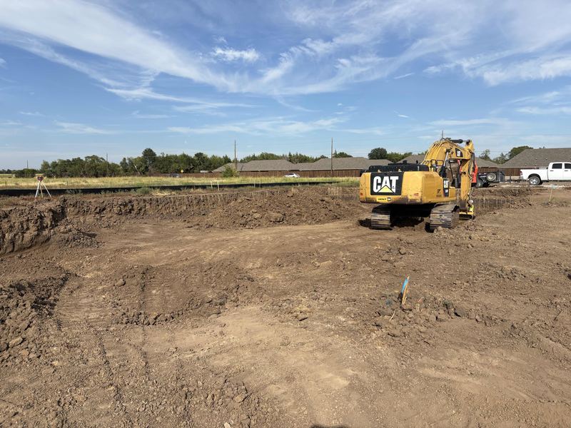 Excavator working across a wide commercial excavation